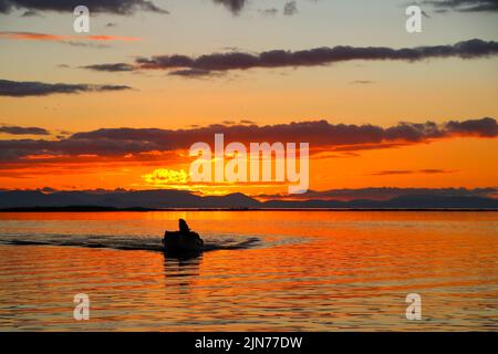 Sonnenuntergang in Izmir - Türkei. Meer- und Sonnenuntergangsfarben auf den Wolken. Bootsblick auf das Meer bei Sonnenuntergang Stockfoto