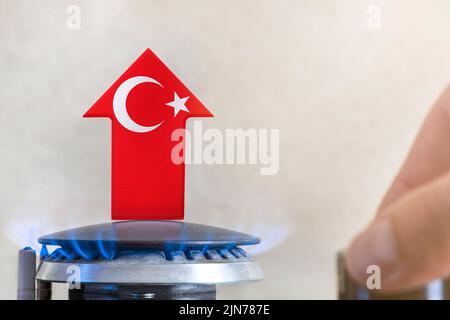 Gaspreis. Anstieg der Gaspreise in der Türkei. Ein Brenner mit einer Flamme und einem Pfeil nach oben, gemalt in den Farben der Türkei-Flagge. Das Konzept des steigenden Gases oder Stockfoto