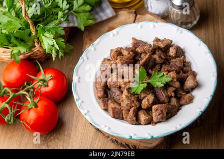 Muslime traditionelle Opfer Urlaub Essen Lamm, türkisch gebratenes Fleisch in Kupfertopf auf der Tischplatte. Türkische Kavurma. (Türkischer Name; Kurban kavurma) Stockfoto