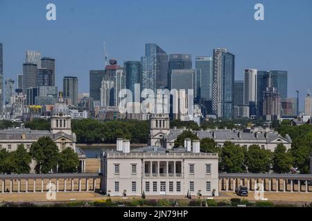 London, Großbritannien. 9.. August 2022. Blauer Himmel über Canary Wharf an einem sengenden Tag, an dem die Hitzewellen und Dürren in Großbritannien anhalten. Das Queen's House ist im Vordergrund zu sehen, vom Greenwich Park aus gesehen. Kredit: Vuk Valcic/Alamy Live Nachrichten Stockfoto