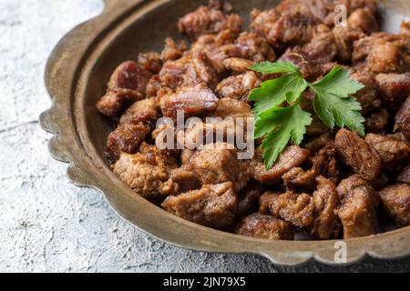 Muslime traditionelle Opfer Urlaub Essen Lamm, türkisch gebratenes Fleisch in Kupfertopf auf der Tischplatte. Türkische Kavurma. (Türkischer Name; Kurban kavurma) Stockfoto