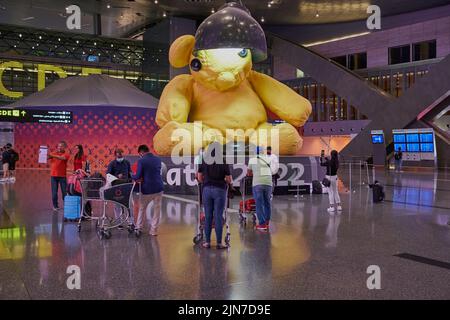 Abflughalle im Hamad International Airport, Doha, Katar bei Nacht mit der großen Lamp Bear Statue des Schweizer Künstlers Urs Fischer und # Qatar 2022 Stockfoto