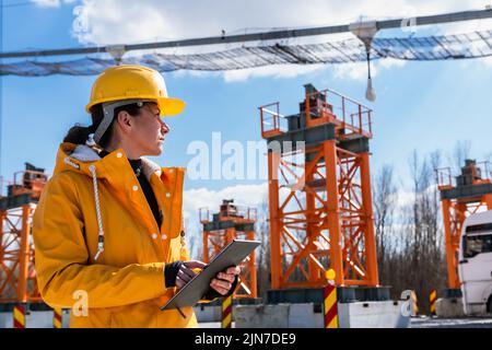 Ingenieurinnen bei der Arbeit in Konstruktionen mit digitaler Tablette, überwachend Stockfoto
