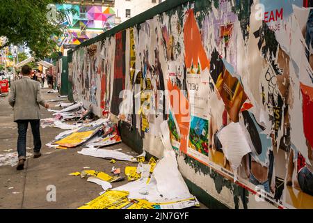 Am Dienstag, den 26. Juli 2022, wurden Werbeplakate aus einem Gehsteig vor einer Baustelle in New York mit Wheatpaste entfernt. (© Richard B. Levine) Stockfoto