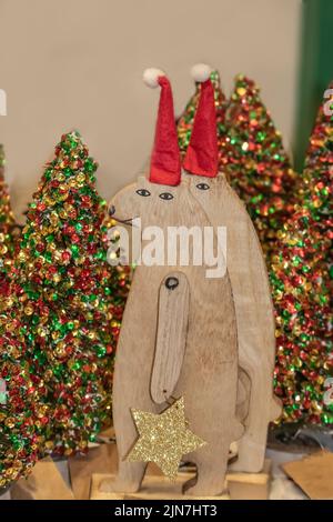 Zwei Holzbären mit Glitzersternen Weihnachtsschmuck vor Bokeh Glitzer Weihnachtsbäumen - selektiver Fokus Stockfoto