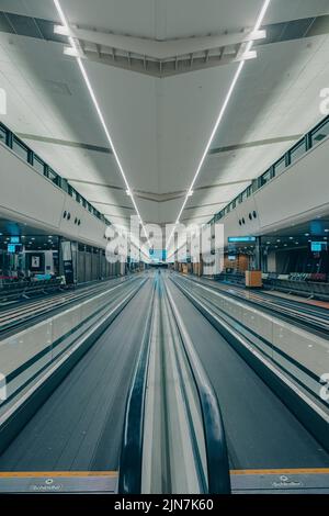 Eine vertikale Aufnahme leerer flacher Rolltreppen auf dem leeren JNB-Flughafen in Südafrika Stockfoto