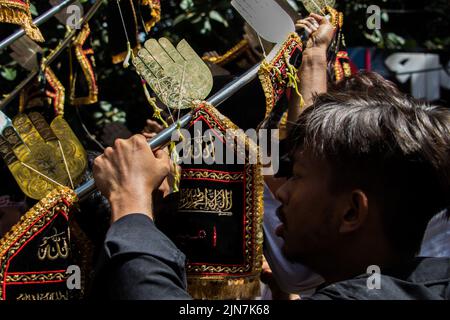 Schiitische Muslime aus Bangladesch marschieren und tragen die Flaggen und Tazia während einer Muharram-Prozession auf der Hauptstraße in Dhaka, Bangladesch, am 09.. August 2022. Stockfoto