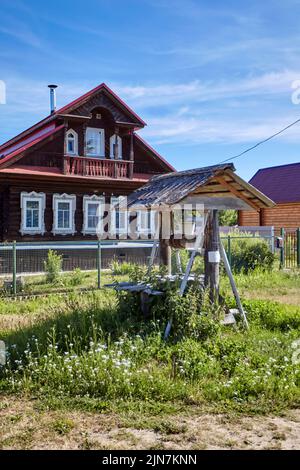 Traditioneller russischer alter Wasserbrunnen im Dorf. Ländliche Landschaft Stockfoto