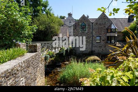 Schöne Aussicht auf eine Fußgängerbrücke über den Fluss Aven in Pont-Aven im Département Finistère der Bretagne im Nordwesten Frankreichs. Stockfoto