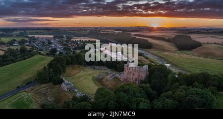 Luftaufnahme bei Sonnenuntergang von Norham Castle, einer der wichtigsten Festungen, die die anglo-schottische Grenze verteidigen. Northumberland, England Stockfoto