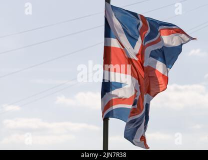 Union Jack Flagge auf einem blauen Himmel Hintergrund im Wind futtering. Die Flagge des Vereinigten Königreichs. Stockfoto