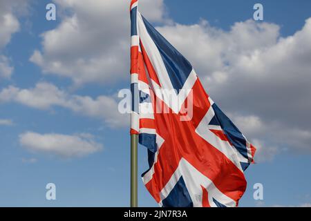 Union Jack Flagge auf einem blauen Himmel Hintergrund im Wind futtering. Die Flagge des Vereinigten Königreichs. Stockfoto