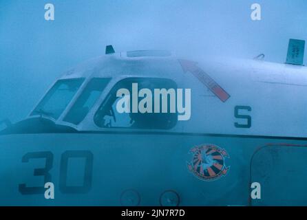 Grumman C-2A Taxis im Nebel auf einem Flugzeugträger-Deck Stockfoto