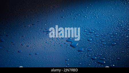 Eine Nahaufnahme von Wassertropfen auf einer blauen Oberfläche Stockfoto