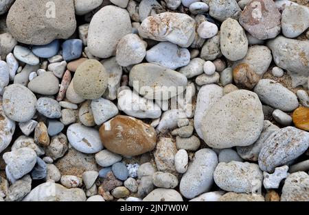 Mehrfarbige Kieselsteine und Strandsand Stockfoto