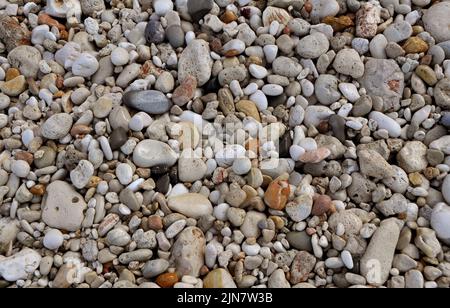 Mehrfarbige Kieselsteine und Strandsand Stockfoto