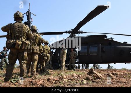 Soldaten des Royal Australian Regiment des Bataillons 5. erhalten von den Soldaten der US-Armee Anweisungen für die ordnungsgemäße Montage im UH-60 Blackhawk-Hubschrauber für ihre gemeinsame Trainingsprobe im Rahmen des Super Garuda Shield 2022 in Baturaja, Indonesien, 8. August 2022. Super Garuda Shield, ein Teil der Operation Pathways und eine langjährige jährliche, bilaterale militärische Übung, die zwischen dem US-Militär, den indonesischen nationalen Streitkräften, durchgeführt wird, hat sich nun zu einer multinationalen Übung mit 14 Nationen erweitert. Diese Übung verstärkt die US-Verpflichtungen gegenüber unseren Verbündeten und anderen r Stockfoto