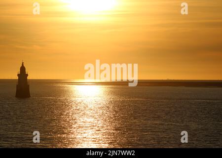 Der Leuchtturm Plover Scar an der Küste von Lancashire in der Mündung des Flusses Lune bei Sonnenuntergang mit Blick über den Sunderland Point in die Morecambe Bay. Stockfoto