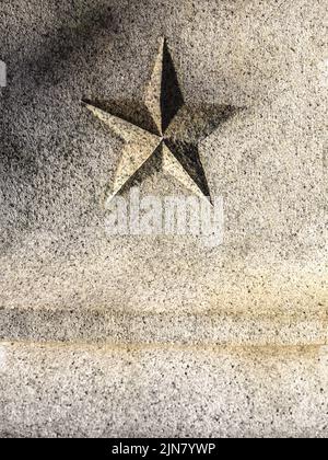 Fünfspitz zulaufender Stern/Pentagramm aus Granit – vertikale Nahaufnahme. Stockfoto
