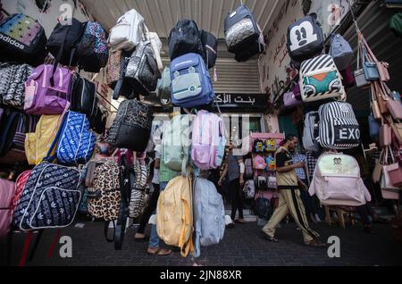 Gaza, Palästina. 09. August 2022. Ein Palästinenser geht am späten Sonntag durch einen Markt in der Stadt Khan Yunis im südlichen Gazastreifen, und zwischen Israel und dem Islamischen Jihad begann eine von Ägyptern vermittelte Waffenruhe, die drei Tage der Gewalt beendete. Kredit: SOPA Images Limited/Alamy Live Nachrichten