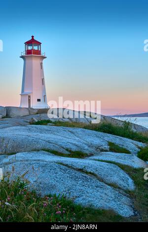 Foto des legendären Peggy's Cove Leuchtturms, aufgenommen bei Sonnenaufgang an einem schönen Sommermorgen. Stockfoto