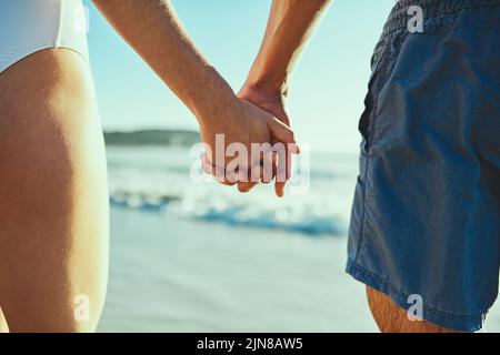 Alles ist gut, wenn du an meiner Seite bist. Nahaufnahme eines Paares, das die Hände am Strand hält. Stockfoto