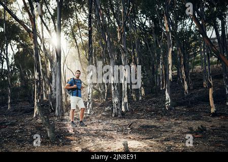 Dies ist ein interessanter Ort, auf den ich gestoßen bin. Ein unbeschwerter junger Mann, der tagsüber draußen auf einen Berg hinaufgeht. Stockfoto