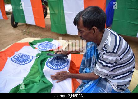 Arbeiter bereiten indische Nationalflaggen bei einem Workshop vor dem indischen Unabhängigkeitstag am Stadtrand von Agartala vor. Tripura, Indien. Stockfoto