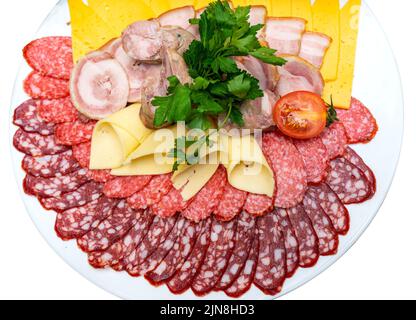 Ein Teller mit kalten Vorspeisen mit verschiedenen Würstchen, Fleisch und Käse. Gemüse und Tomaten. Isolieren. Stockfoto