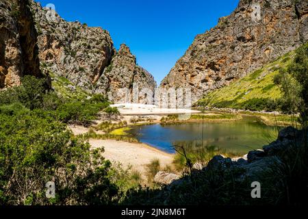 Panoramablick auf ein Tal mit Teich in der tiefen Schlucht mit Flussufer des Torrent de Pareis und dem Strand Cala de Sa Calobra. Stockfoto