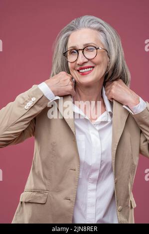 Frau in leichter Jacke stehend und selbstbewusst Stockfoto