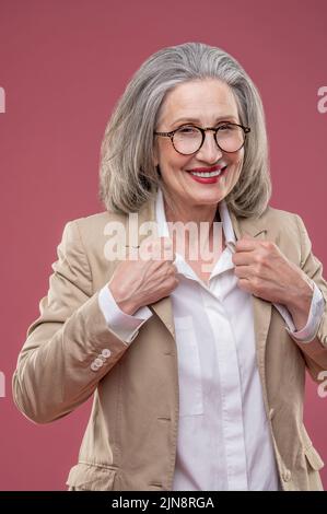 Frau in leichter Jacke stehend und selbstbewusst Stockfoto