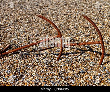 Zwei Anker, die mit kommerzieller Fischereiausrüstung am Kiesstrand in North Norfolk in Cley-next-the-Sea, Norfolk, England, Vereinigtes Königreich, gelagert wurden. Stockfoto