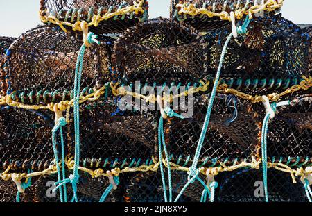 Eine Nahaufnahme von Krabben-/Hummertöpfen am Kiesstrand in North Norfolk, bereit für den Einsatz in Cley-next-the-Sea, Norfolk, England, Großbritannien. Stockfoto