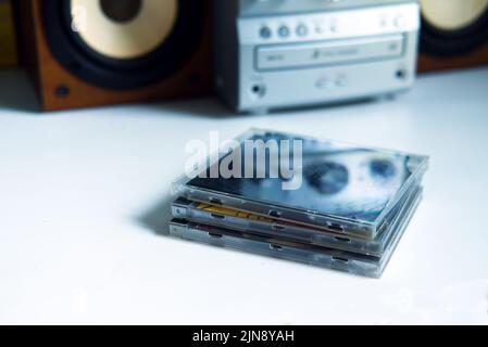 Mini-Stereoanlage aus dem Jahr 90s und alte cds auf weißem Regal Stockfoto