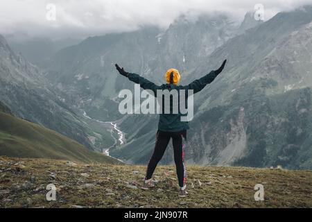 Junge Wanderer Trekking in Svaneti, Georgien. Shkhara Berg im Hintergrund. Unglaublich schöne WELT. Fantastischer Himmel Hintergrund mit blauen Wolken. Stockfoto