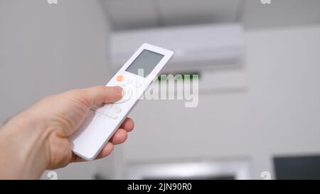 Bedienung der Klimaanlage über die Fernbedienung in der Hand Stockfoto