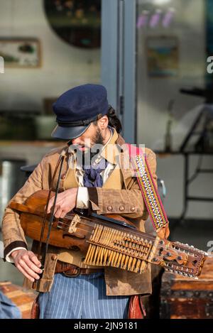 Ein Musiker aus der alten Zeit Matrosen Tuning einer Nyckelharpa am Newquay Orchard Amphitheater in Cornwall. Stockfoto