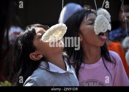 Jakarta, Indonesien - 17. August 2014 : Kinder nehmen an einem Cracker-Eating-Wettbewerb zur Feier des Unabhängigkeitstages Indonesiens in Jaka Teil Stockfoto