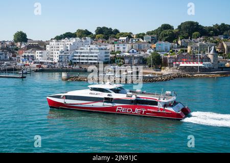 Der Red Jet, ein von Red Funnel betriebener Hochgeschwindigkeits-Katamaran, macht sich in den Sommerferien auf den Weg nach West Cowes auf der Isle of Wight. Stockfoto