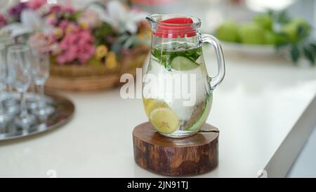 Auf dem Tisch in Krug mit Gurke, Zitrone und Minze entgiftetes Wasser aufgießen Stockfoto