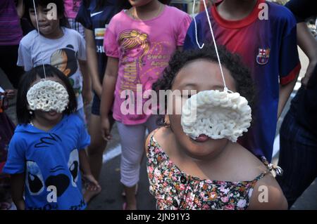 Jakarta, Indonesien - 17. August 2014 : Kinder nehmen an einem Cracker-Eating-Wettbewerb zur Feier des Unabhängigkeitstages Indonesiens in Jaka Teil Stockfoto