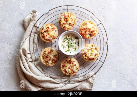 Miniportionen von Flammekueche oder Flammkuchen, französische und deutsche Spezialität, auf dem runden Kühlgitter aus Metall, Draufsicht Stockfoto