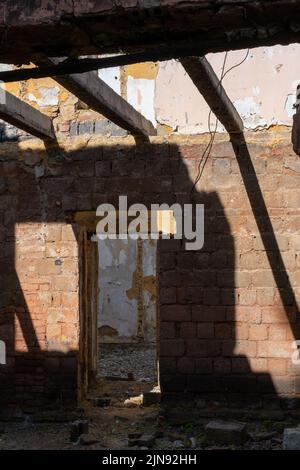 Kaputte Wände, Fenster. Der Prozess des Abrissens eines alten Gebäudes. Abriss von baufälligen Wohnungen für Neuentwicklung Stockfoto