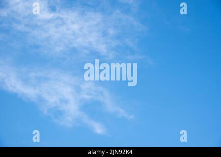 Blauer Himmel Hintergrund mit weißen flauschigen Cumulus Wolken. Panorama von weißen, flauschigen Wolken am blauen Himmel. Wunderschöner, riesiger blauer Himmel mit erstaunlichen verstreuten Stockfoto