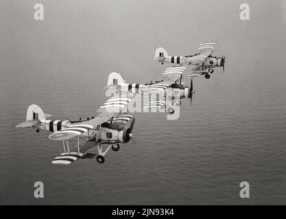 Drei Fairey-Schwertfische mit Invasionsstreifen wurden während eines Trainingsfluges von der Royal Naval Air Station St. Merryn in der Nähe von Newquay, Cornwall, England, für die Landung in der Normandie getragen. Obwohl der Schwertfisch bis 1939 überholt war, erzielte er während des Krieges spektakuläre Erfolge, insbesondere den Angriff auf das deutsche Schlachtschiff Bismarck, der zu seinem endgültigen Untergang beitrug. Der Schwertfisch sank eine größere Tonnage der Achsenschifffahrt als jedes andere alliierte Flugzeug während des Krieges und blieb bis zum V-E Day im Frontdienst, nachdem er einige der Flugzeuge, die es ersetzen sollten, überlebt hatte. Stockfoto