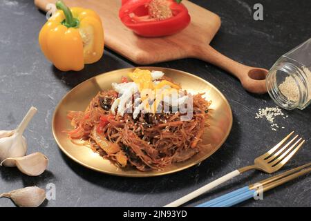 Koreanischer Japchae-Noodle, Cellophane-Noodle mit Rind und Rühr-Fritten-Gemüse. Belag mit Ei und Sesamsamen Stockfoto