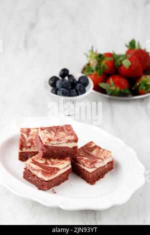 Red Velvet Quadrate Brownies in einem Stapel auf einem weißen Teller Stockfoto