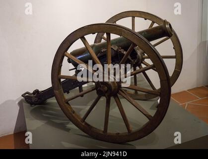 Eine alte und gebrauchte Haubitzerpistole mit zwei Fersen auf dem grünen Ständer Stockfoto