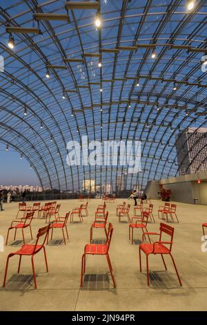 Eine vertikale Aufnahme von roten Stühlen und der Glasdecke der Dolby Family Terrace im Academy Museum of Motion Picturs Stockfoto